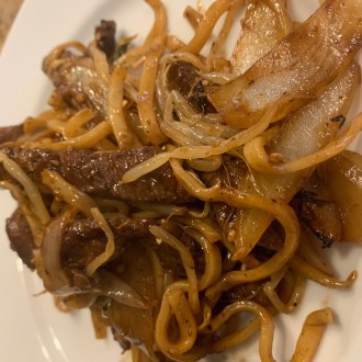 Mulan Noodles also known as Beef Chow Fun on a white plate